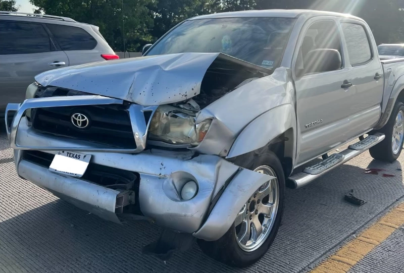 Blog 5 Wrecked Toyota Tacoma with severe front-end collision damage.