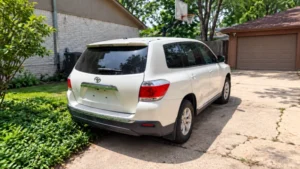 SUV blanco visto desde atrás en una entrada residencial con garaje cerrado