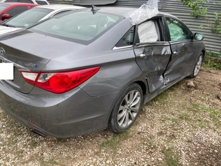 Wrecked gray Hyundai sedan with severe side impact damage, illustrating a vehicle bought for cash by Junk Car Buyers R-Us in Texas City, TX.
