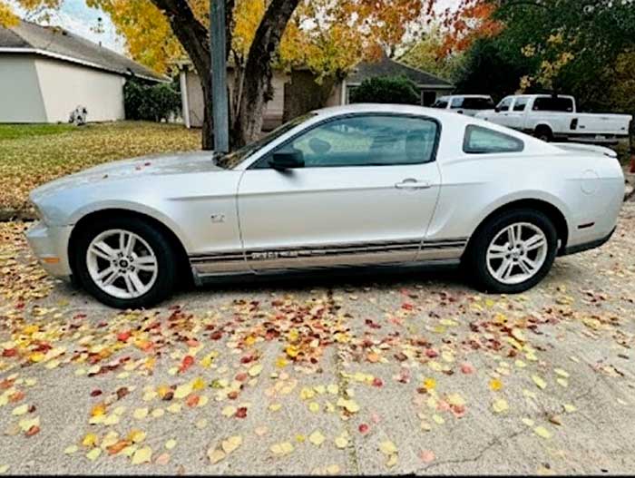 Silver Ford Mustang with major transmission issues parked in front of a house in Richmond, TX, purchased by Junk Car Buyers R-Us