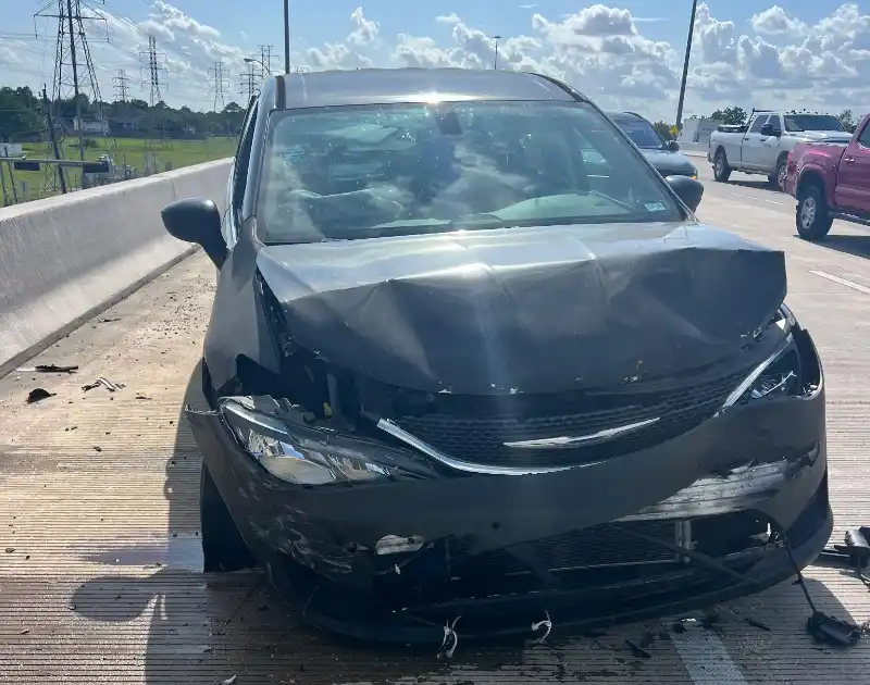 Wrecked black car on highway ready for pickup in The Woodlands, TX