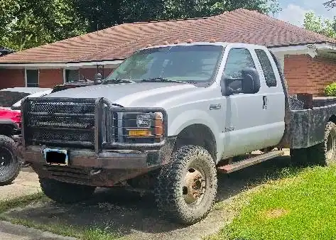 Silver 2004 Ford F-350 work truck parked in a driveway in Humble, TX.