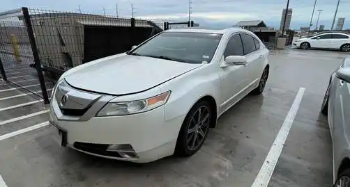 Acura blanco usado estacionado en un lote pavimentado.
