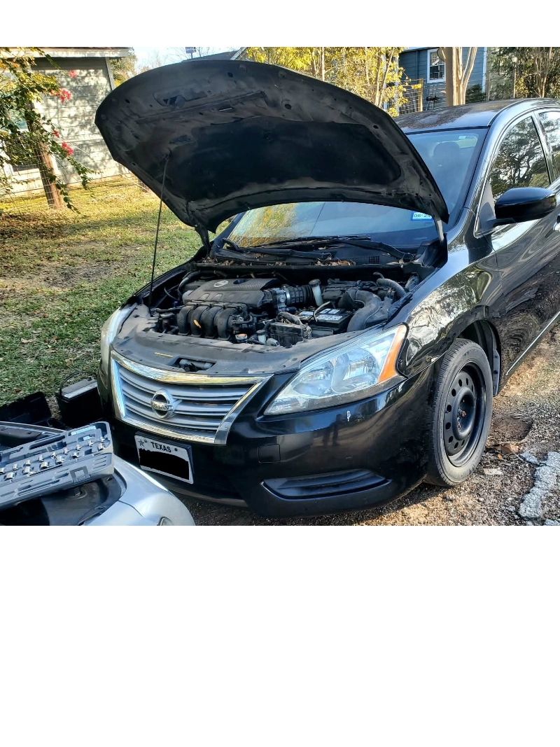 Black Nissan Altima with hood open parked in a driveway in Hockley, TX.