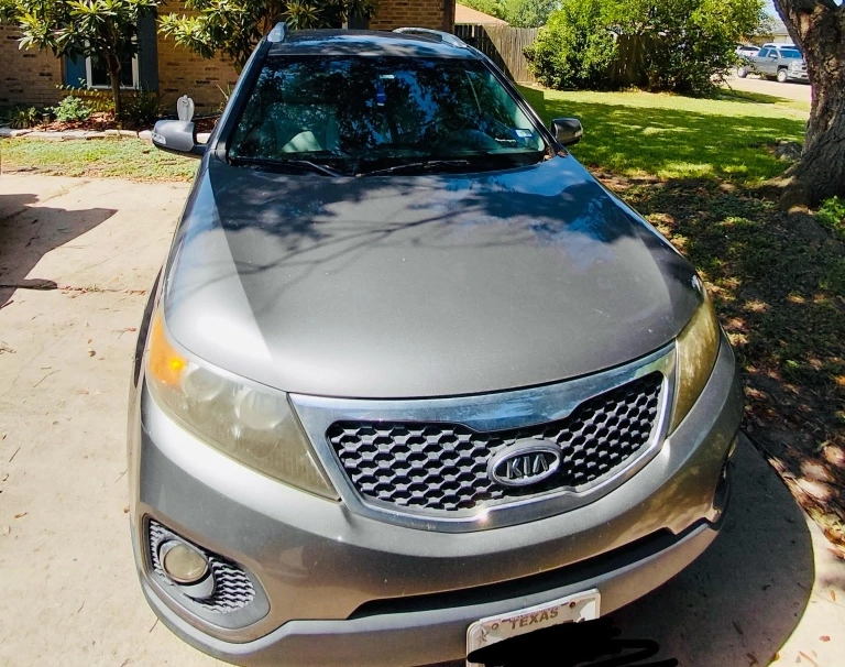 Gray Kia SUV parked in a residential driveway in Atascocita, TX.