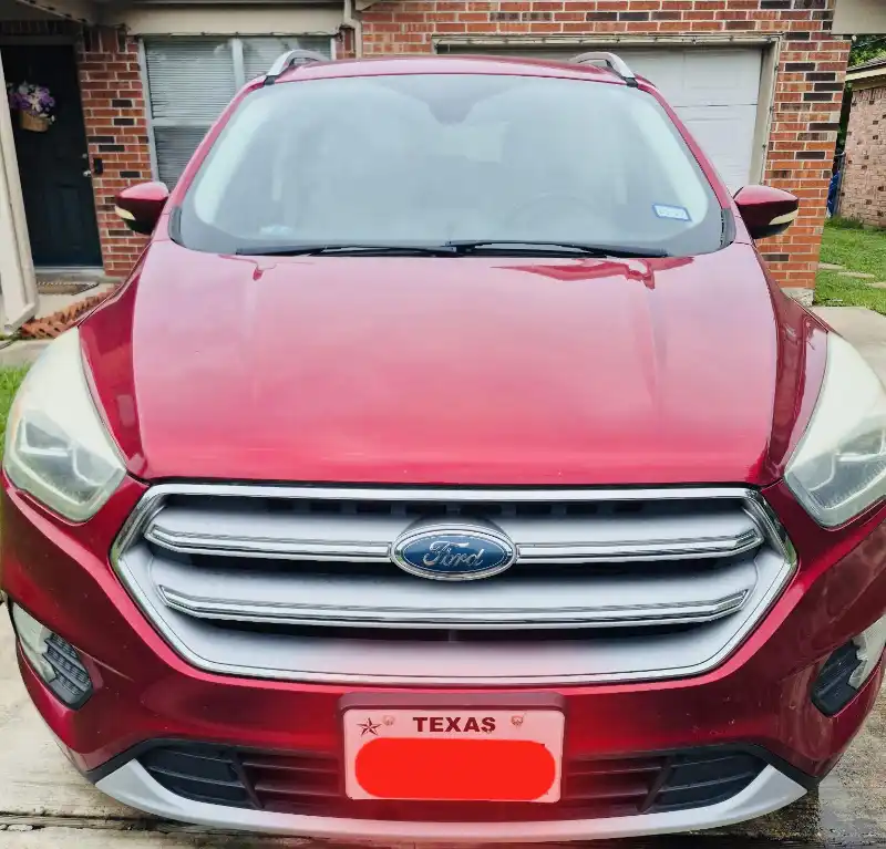 Front view of a red Ford SUV parked in a residential driveway.