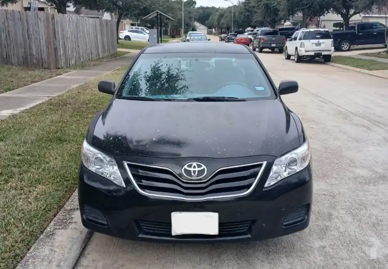 Toyota negro estacionado en una calle residencial.
