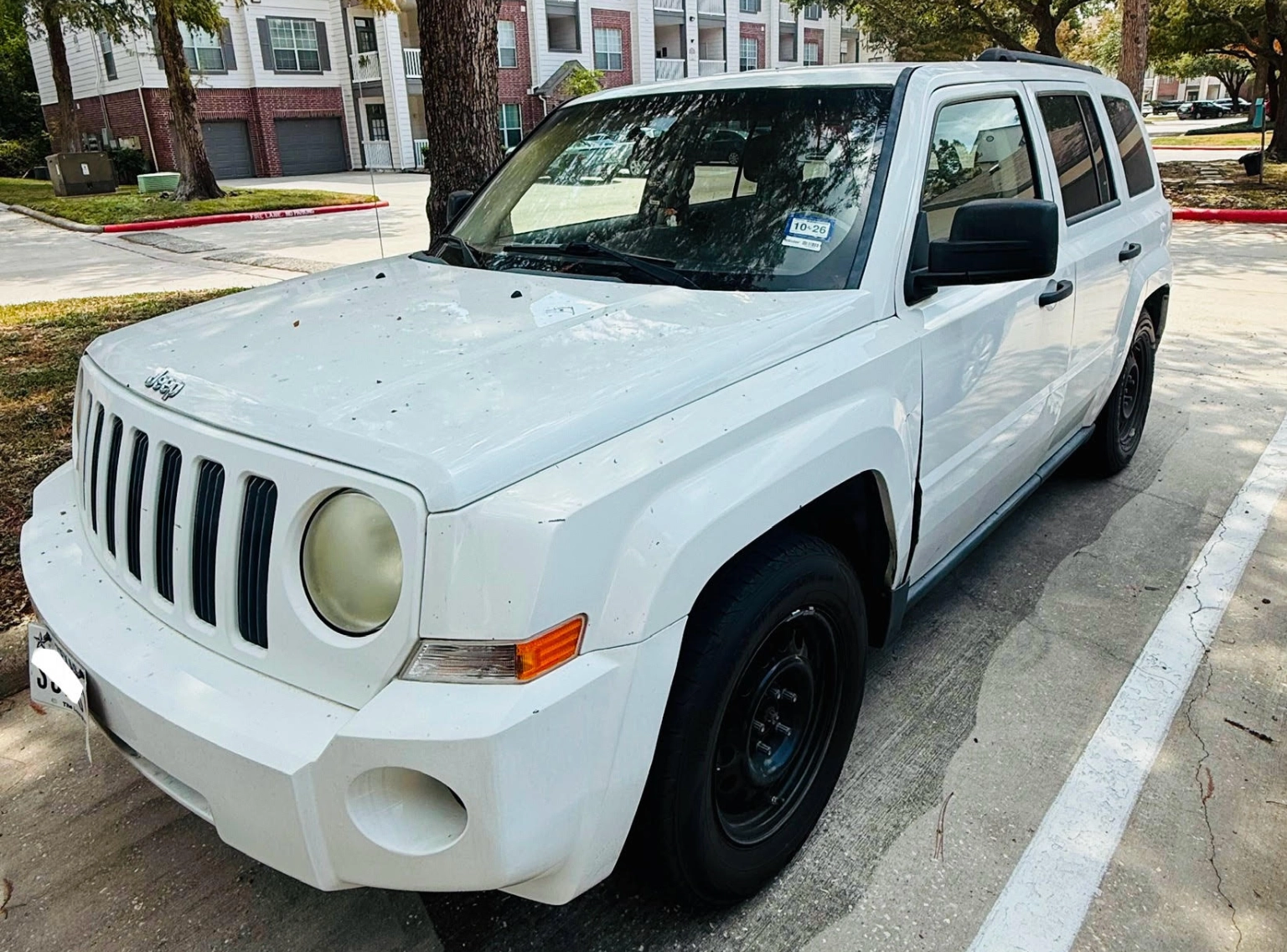 White Jeep SUV parked at an apartment complex in Baytown, TX.