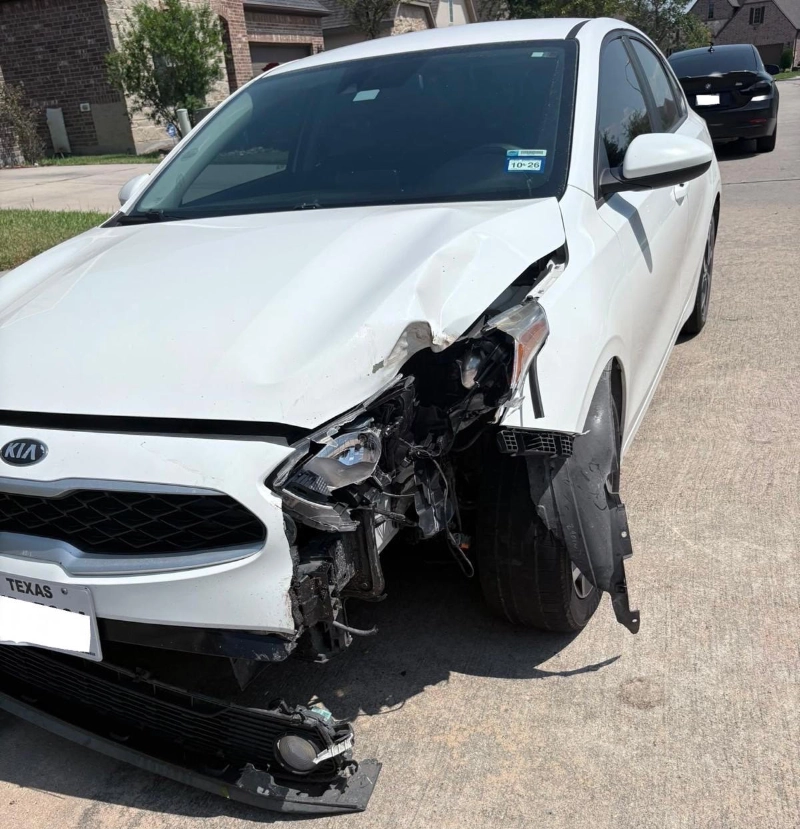 White Kia Optima with severe front-end collision damage in La Porte, TX.